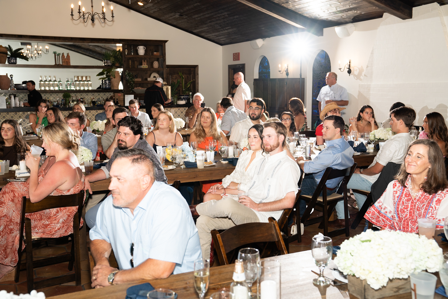 Hilary and Jackson sit surrounded by their friends during a toast